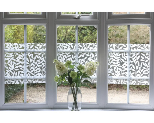 Okno s fólií na ochranu soukromí s rostlinným vzorem a kyticí květin ve váze