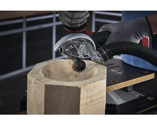 Osoba tvaruje misku z kusu dřeva pomocí frézovacího nástavce