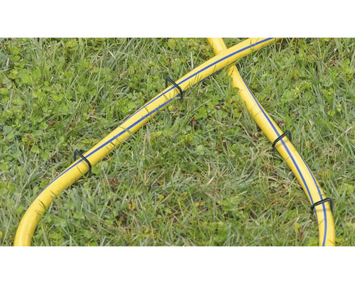 Žlutá zahradní hadice s držáky hadice v trávě