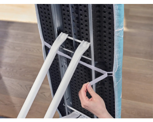 Detailní pohled na žehlicí prkno s rámem a napínacím popruhem