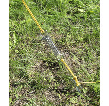 Stanová pružina s kolíkem a šňůrou ve trávě