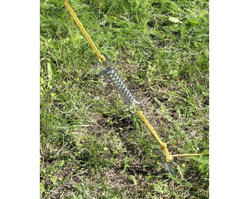 Stanová pružina s kolíkem a šňůrou ve trávě