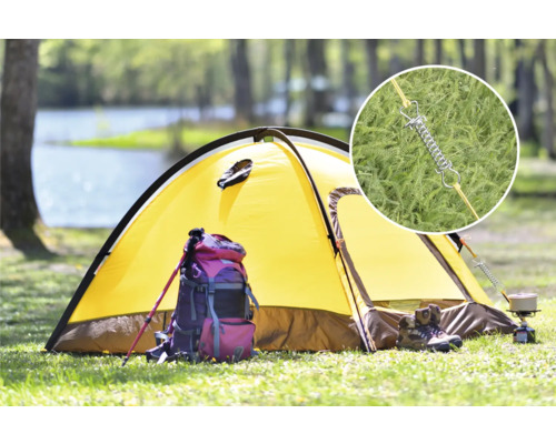 Žlutý stan na louce s batohem, trekovými holemi a kempingovým vařičem. Detailní záběr pružiny stanu