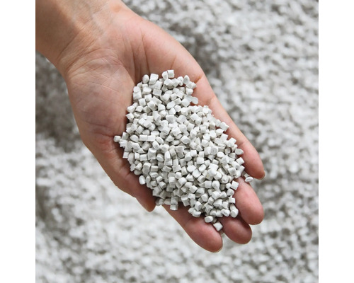 Ruka drží stelivo pro kočky z minerálního materiálu