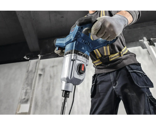 Stavební dělník obsluhuje demoliční kladivo.