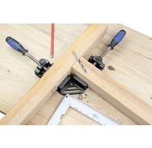 Pracovní stůl s dřevem, šroubovací svěrky, úhelník a vrták