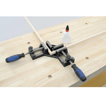 Rohová svorka drží dva kusy dřeva v úhlu 90 stupňů na pracovní lavici.