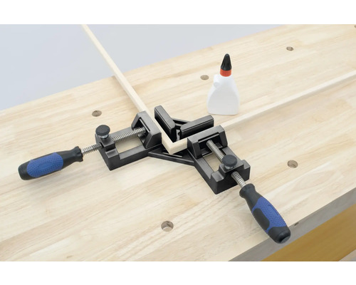 Rohová svorka drží dva kusy dřeva v úhlu 90 stupňů na pracovní lavici.