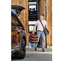 Muž nese tři kufříky s nářadím k autu