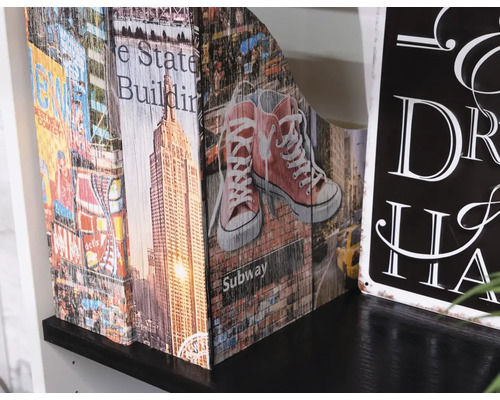 Dekorativní stojan na časopisy s motivem New Yorku na polici.