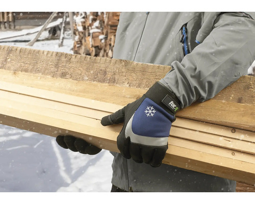 Osoba nosí pracovní rukavice a drží dřevěné desky