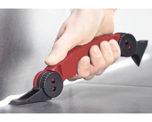 Ruka s červeným spárovacím nástrojem nanášející tmel