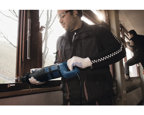 Řemeslník demontuje okno pomocí ocasky.