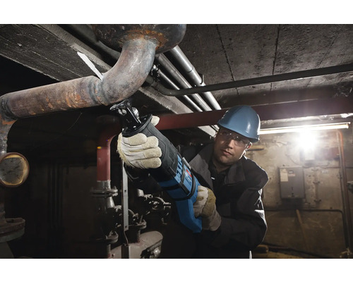 Řemeslník řeže trubku ocaskou pilou