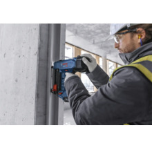 Pracovník používá nastřelovací pistoli na staveništi.