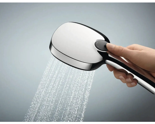 Ruční sprcha s proudem vody a ovládacím knoflíkem v ruce