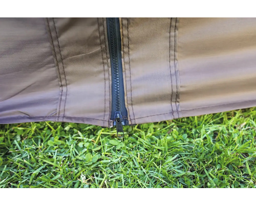 Detailní pohled na zip stanu s trávou v popředí.