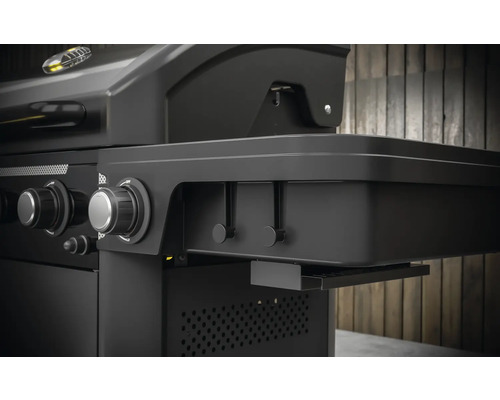 Detail plynového grilu s bočním stolkem, otočnými knoflíky a lištou s háčky