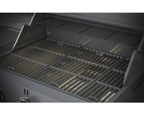 Vnitřní pohled na plynový gril s grilovacím roštem a ohřívacím roštem.