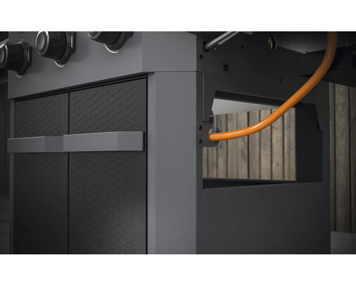 Detail plynového grilu se skříňkami a plynovým potrubím.