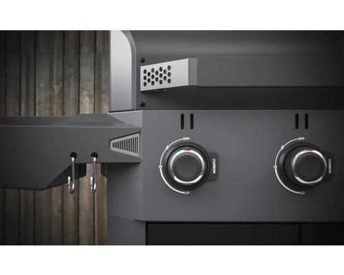 Detailní záběr grilu na dřevěné uhlí s otočnými knoflíky pro regulaci teploty