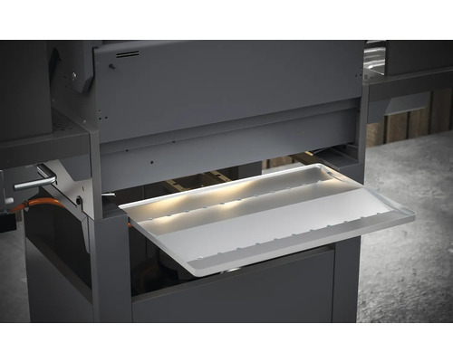 Detailní pohled na gril s vysunutou nádobou na odkapávající tuk.