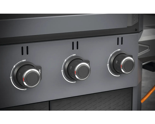 Detailní záběr otočných knoflíků plynového grilu pro regulaci tepla.