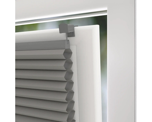 Detailní pohled na šedou plisovanou žaluzii na okně