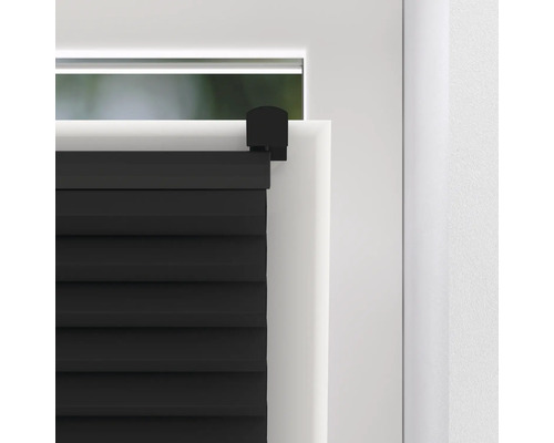 Detail černých skládaných žaluzií na okně