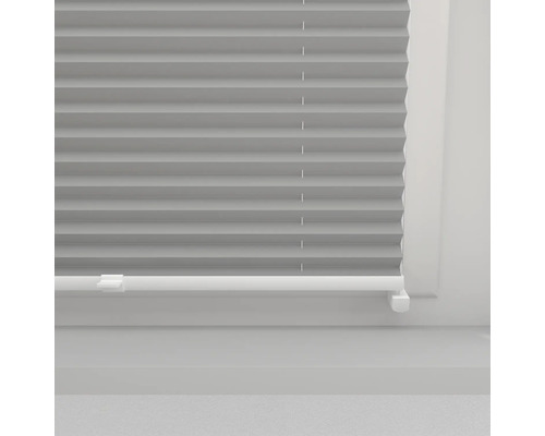 Šedá plisovaná žaluzie v okně