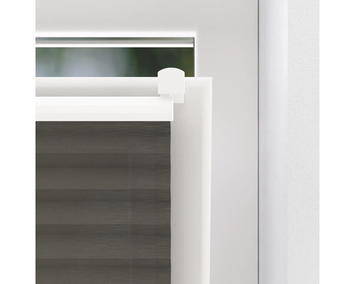 Detailní pohled na šedou plisovanou žaluzii na okně