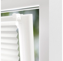 Detailní pohled na bílou plisovanou žaluzii na okně