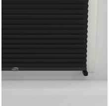 Detail černého plisovaného závěsu před oknem