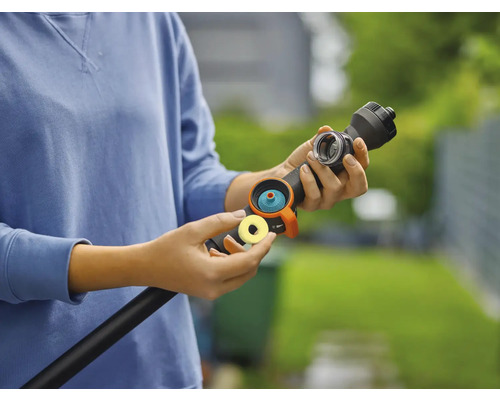 Osoba připojuje hadicovou spojku k zahradní hadici