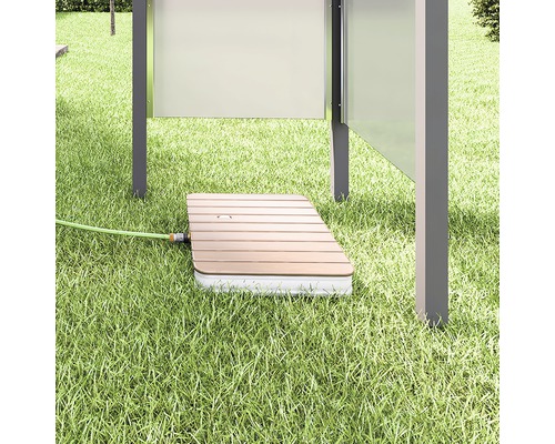 Zapuštěná krabice postřikovače v trávníku s připojenou zahradní hadicí