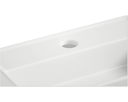 Detailní pohled na bílé umyvadlo s otvorem pro baterii