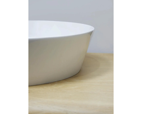 Detailní pohled na bílé umyvadlo na desku na světlém dřevěném povrchu