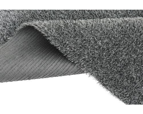 Šedý umělý trávník se stočeným rohem ukazující zadní stranu