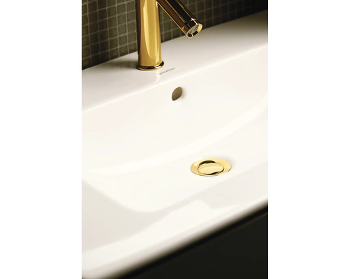 Snímek umyvadla se zlatou baterií a odtokem