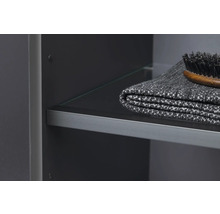 Detail koupelnové skříňky se skleněnou policí, ručníkem a kartáčem