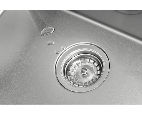 Detailní pohled na nerezový dřez s odtokovou soupravou