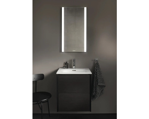 Koupelna s umyvadlovou skříňkou, umyvadlem na desku, vodovodní baterií a osvětlenou zrcadlovou skříňkou