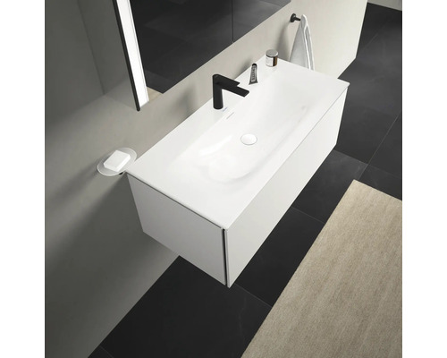 Moderní koupelna s bílým umyvadlem, černou baterií a minimalistickým designem