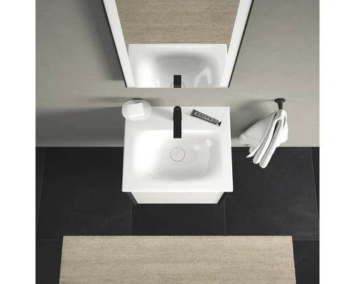 Pohled shora na koupelnu s umyvadlem, mýdlem, ručníkem a zrcadlem