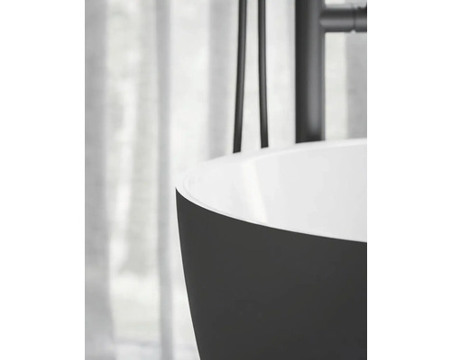 Detailní pohled na volně stojící vanu s černým vnějškem a bílým vnitřkem