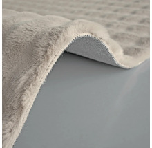 Detail šedého koberce s chlupatým povrchem