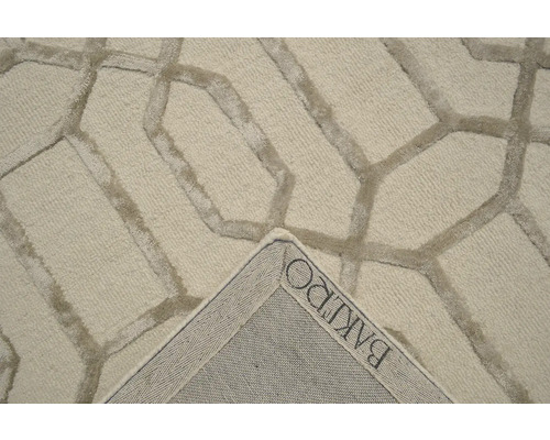 Detailní pohled na koberec s geometrickým vzorem a logem výrobce BAKIRO