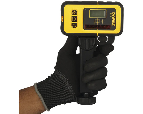 Ruka v rukavici drží žlutý a černý laserový detektor DeWalt