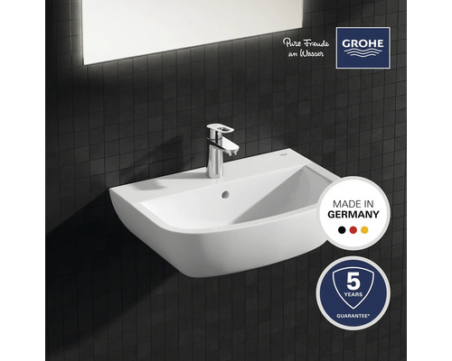 Keramické umyvadlo s baterií na tmavém dlaždicovém pozadí, pečeť kvality Vyrobeno v Německu, logo Grohe, pětiletá záruka
