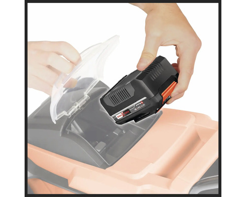 Muž vkládá baterii do sekačky na trávu.